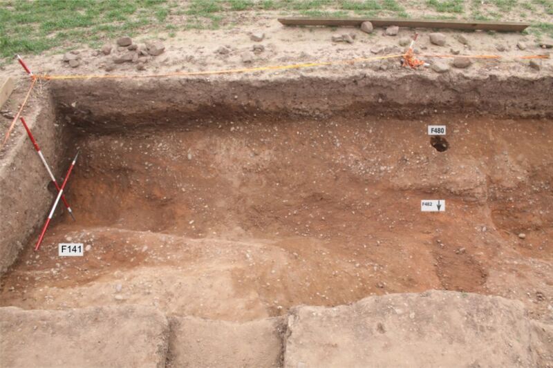Plate 21. T16. The ditch F141 & F148 left and right of the trench with the entrance F482 centre. F480, a posthole in the entrance, contained only clean fill.