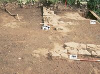 Plate 10. The southwest corner of 4th century enclosure wall, rubbish pit to the right.