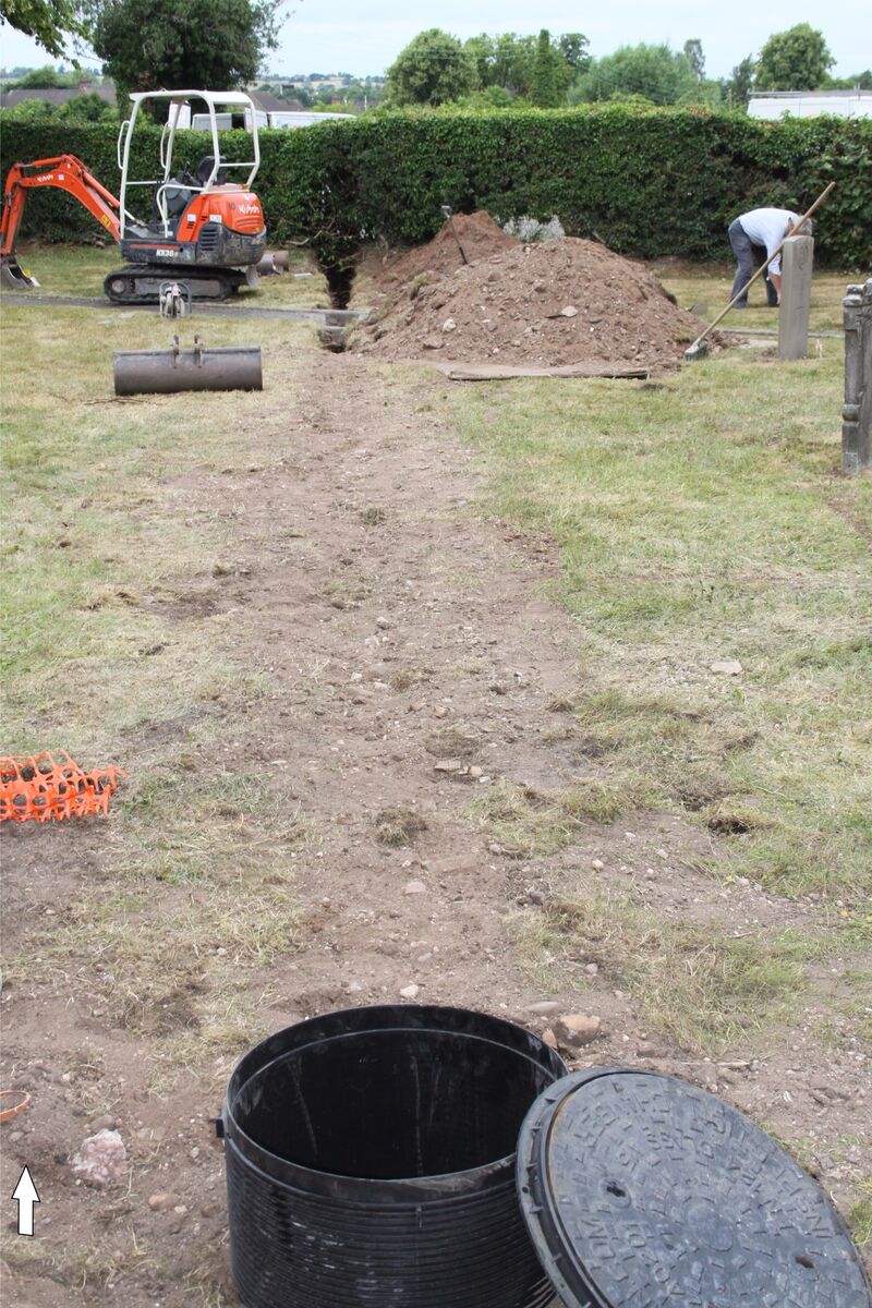 Plate 63. Churchyard Trench no 4. for the foul sewer pipe, part filled with manhole. The manhole now sits over the tegulae wall F4